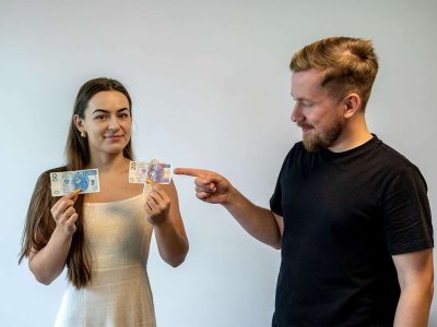 Przykład neuromarketingu. Jedna osoba wskazująca na banknot w dłoni drugiej osoby o mniejszym nominale.